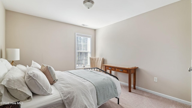 bedroom with baseboards, visible vents, and light colored carpet