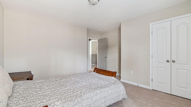 carpeted bedroom featuring a closet and baseboards