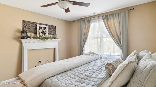 carpeted bedroom featuring visible vents, ceiling fan, and baseboards