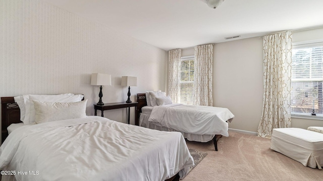 carpeted bedroom featuring visible vents and baseboards