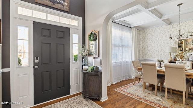 entrance foyer with plenty of natural light, coffered ceiling, wood finished floors, and wallpapered walls