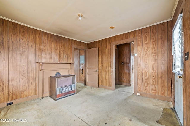 empty room featuring baseboards, wooden walls, ornamental molding, and carpet flooring