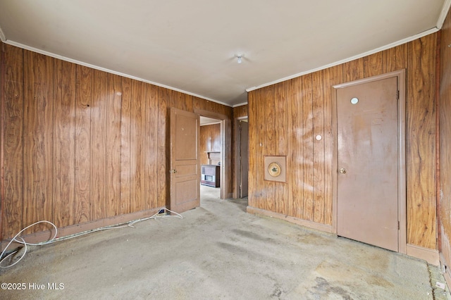 unfurnished room with wood walls and ornamental molding