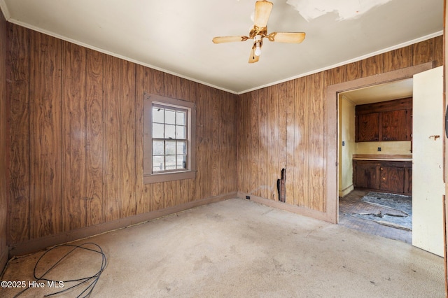 spare room with ceiling fan, ornamental molding, and carpet