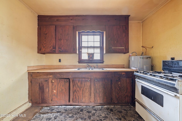 kitchen with ornamental molding, light countertops, a sink, and white gas range