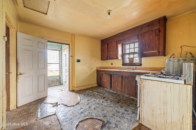 kitchen with crown molding, light countertops, a sink, and white range with gas cooktop