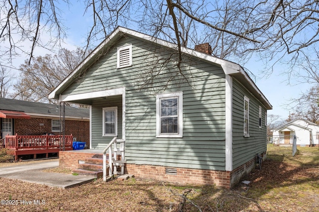 rear view of house with crawl space, a chimney, and a deck