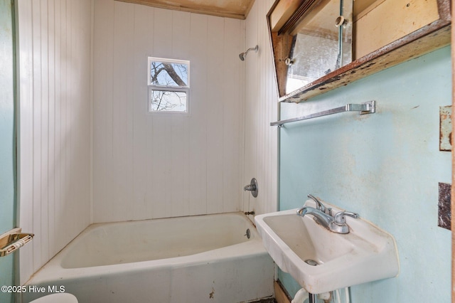 bathroom featuring washtub / shower combination and a sink