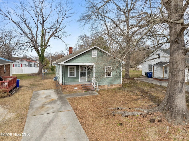 bungalow featuring an outbuilding, fence, crawl space, a front lawn, and a chimney