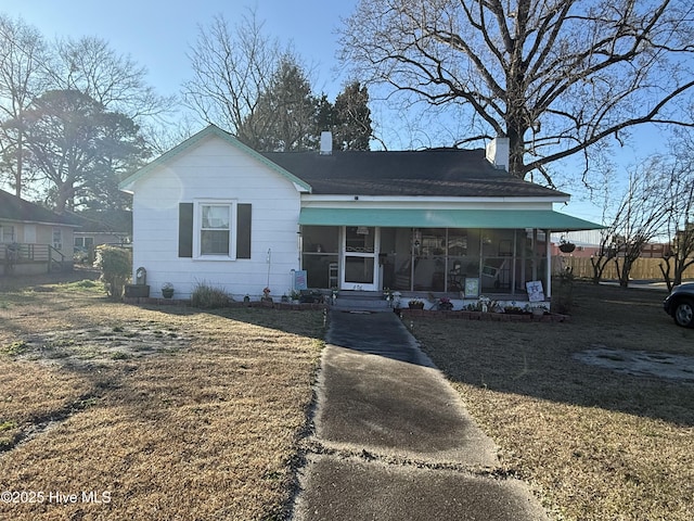 view of front of home featuring a sunroom and a chimney