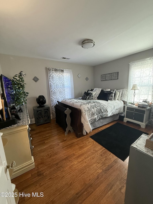 bedroom with visible vents and wood finished floors