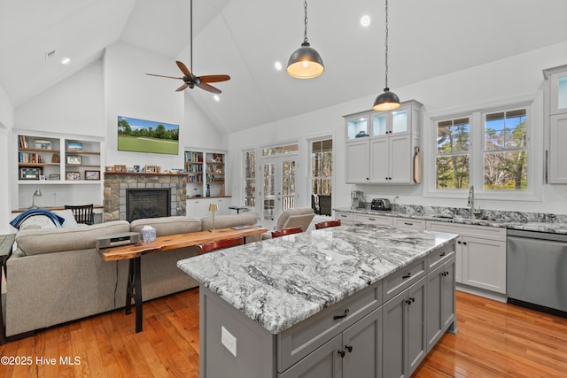 kitchen with plenty of natural light, gray cabinets, dishwasher, and a sink