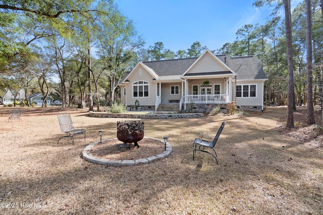 rear view of house featuring a shingled roof, an outdoor fire pit, crawl space, and covered porch