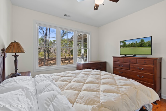 bedroom featuring visible vents, ceiling fan, and wood finished floors