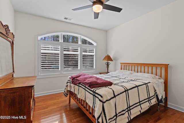 bedroom featuring visible vents, baseboards, ceiling fan, and hardwood / wood-style floors