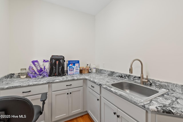 clothes washing area featuring laundry area, a sink, and light wood-style flooring