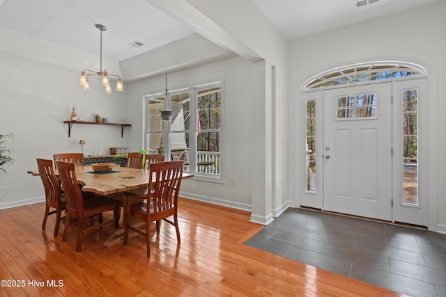 dining room featuring hardwood / wood-style floors, visible vents, and baseboards