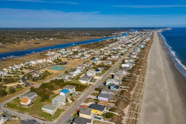 birds eye view of property with a water view and a beach view