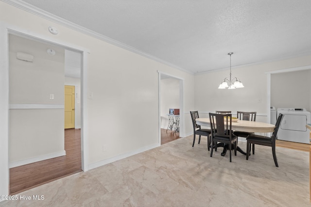 dining area with crown molding, a textured ceiling, a chandelier, independent washer and dryer, and baseboards