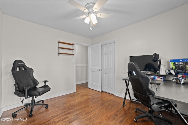 office featuring baseboards, a ceiling fan, and wood finished floors