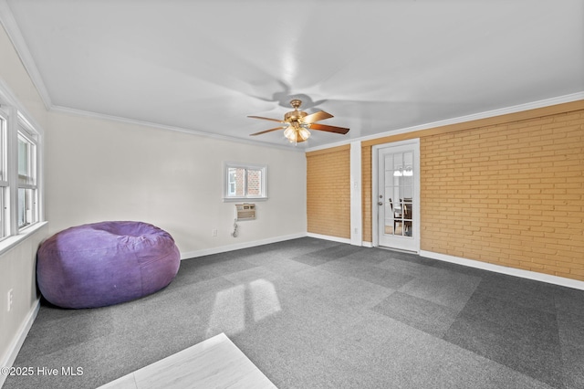 sitting room featuring ceiling fan, brick wall, carpet floors, and crown molding