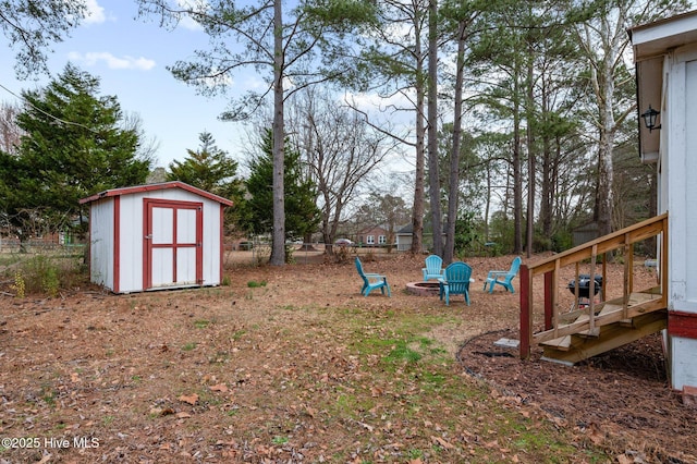 view of yard with a shed, a fire pit, and an outdoor structure