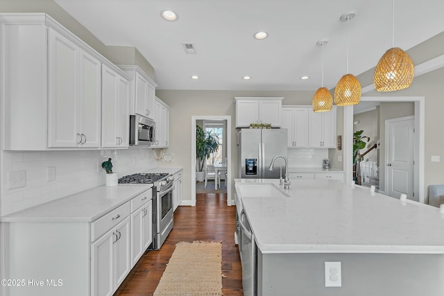 kitchen with visible vents, a spacious island, dark wood-style flooring, a sink, and stainless steel appliances