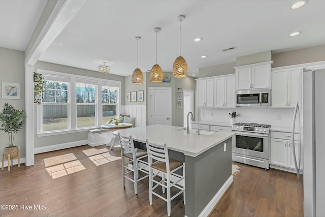 kitchen featuring visible vents, a sink, tasteful backsplash, appliances with stainless steel finishes, and white cabinets