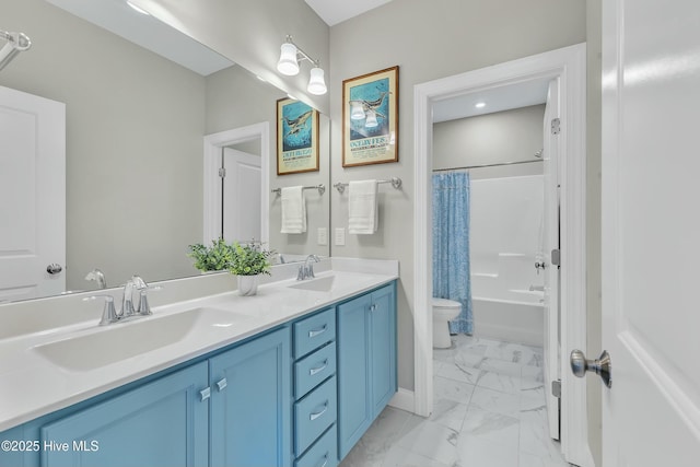 bathroom featuring double vanity, marble finish floor, toilet, and a sink