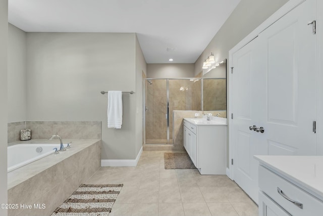 full bath featuring tile patterned flooring, baseboards, a stall shower, a bath, and vanity