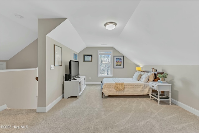 bedroom with baseboards, lofted ceiling, and carpet