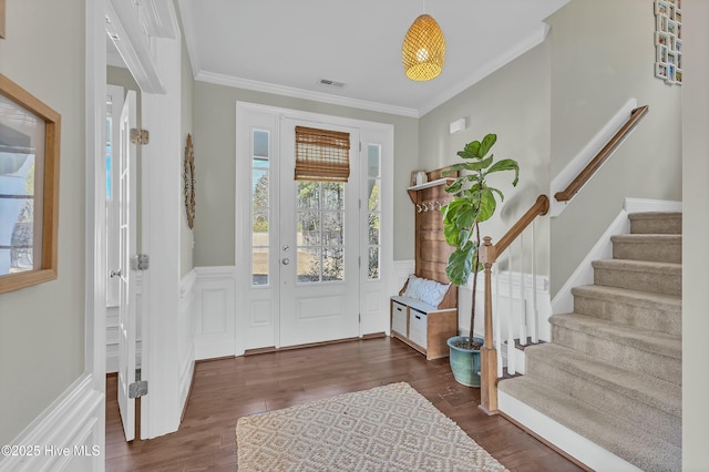 foyer with stairs, visible vents, dark wood finished floors, and crown molding