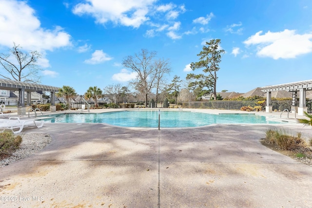 pool with a patio area, a pergola, and fence