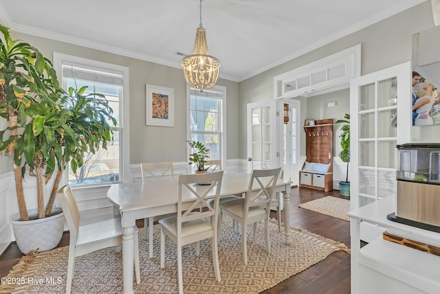 dining space featuring a wainscoted wall, visible vents, an inviting chandelier, dark wood-style flooring, and ornamental molding