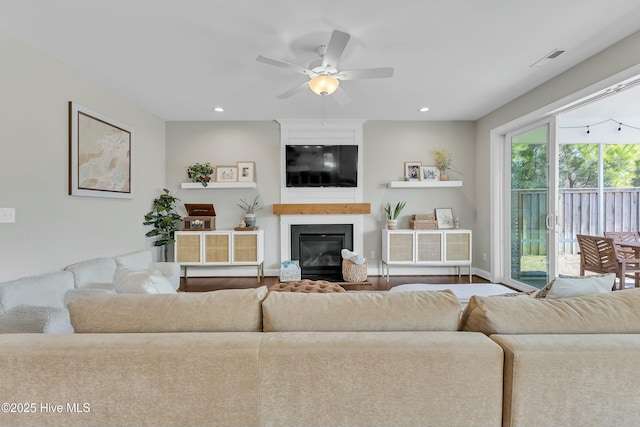 living area featuring visible vents, recessed lighting, a large fireplace, and a ceiling fan