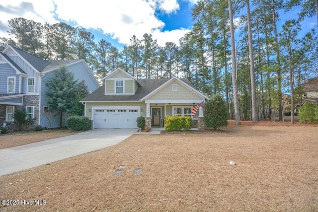 craftsman-style home featuring stone siding, covered porch, and concrete driveway