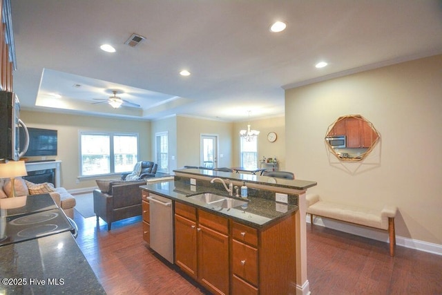 kitchen with visible vents, dark wood finished floors, stainless steel appliances, a sink, and open floor plan