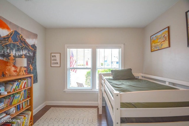 bedroom with baseboards and wood finished floors