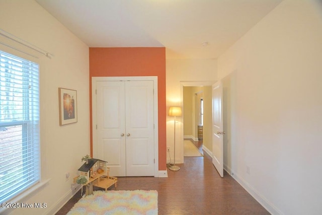 interior space with plenty of natural light, baseboards, and wood finished floors