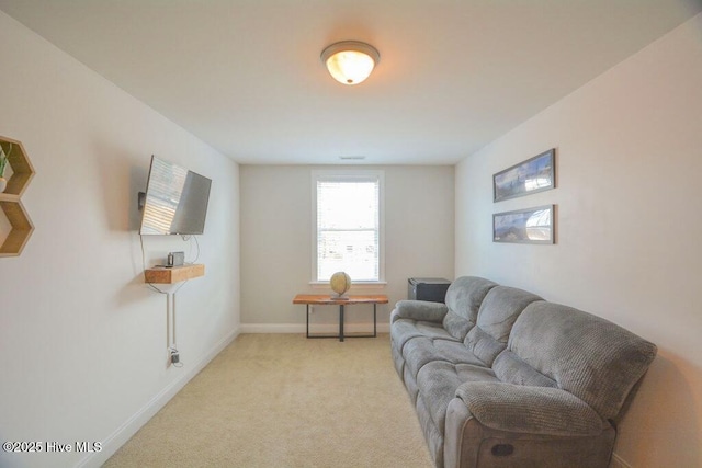 living area featuring light colored carpet and baseboards