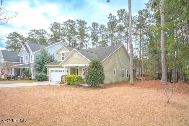 craftsman-style house with a garage, driveway, and fence