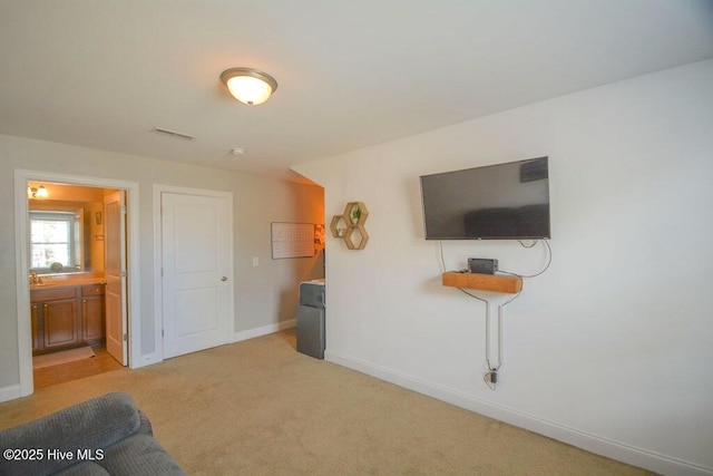 living area with light colored carpet, visible vents, and baseboards