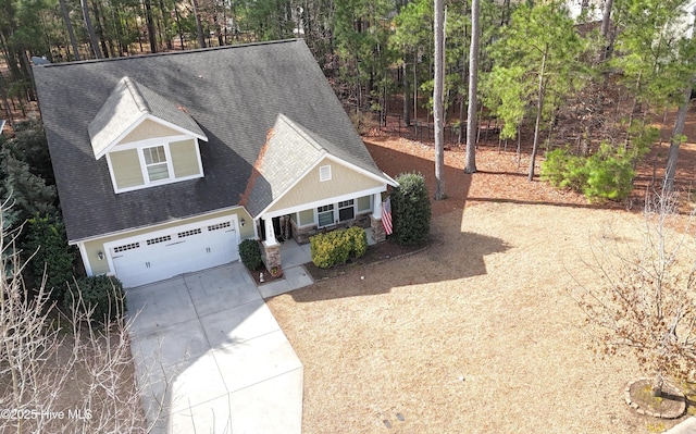 view of front of property featuring a garage, concrete driveway, and a shingled roof