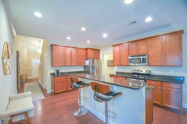 kitchen with dark wood-style floors, appliances with stainless steel finishes, and crown molding