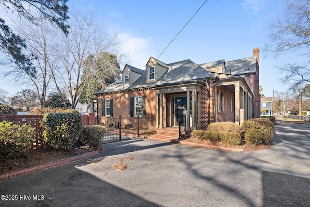 view of front facade with a gate, fence, and brick siding