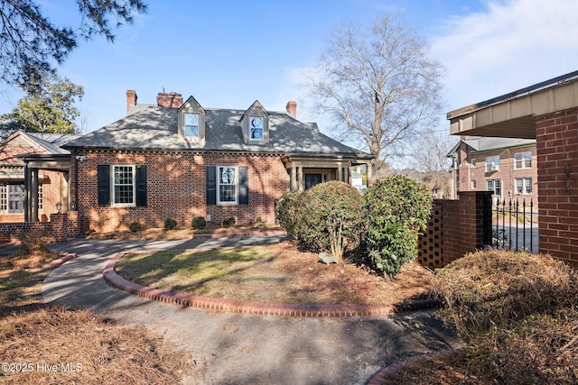 view of front of property with a chimney and brick siding