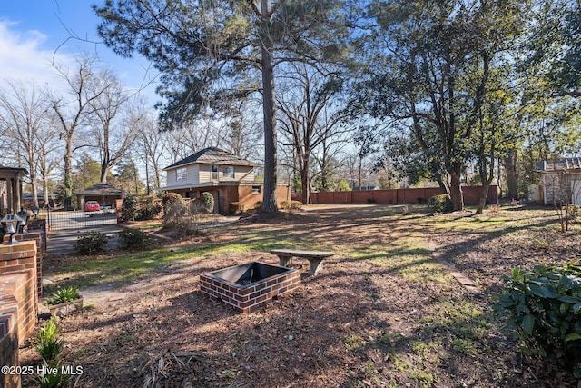 view of yard featuring an outdoor fire pit and fence