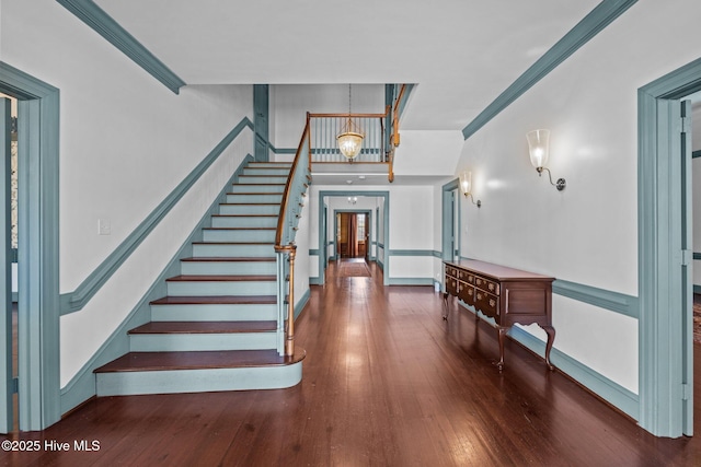 foyer entrance featuring ornamental molding, stairway, and hardwood / wood-style flooring