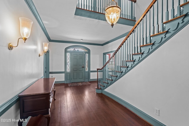 entrance foyer featuring stairs, ornamental molding, hardwood / wood-style flooring, and baseboards