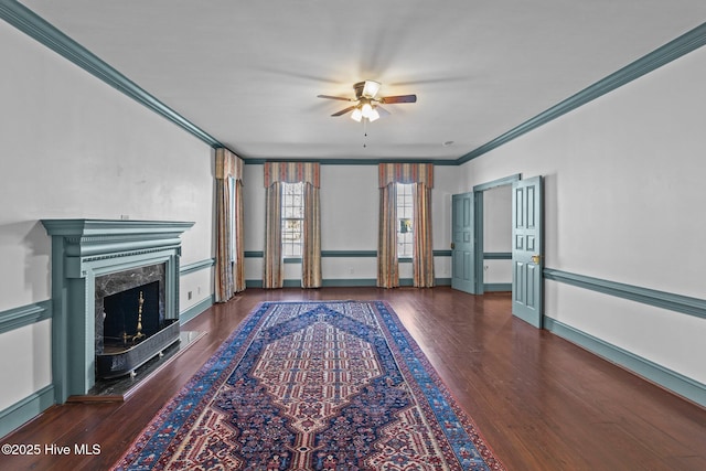 unfurnished living room with ceiling fan, ornamental molding, wood finished floors, and a high end fireplace